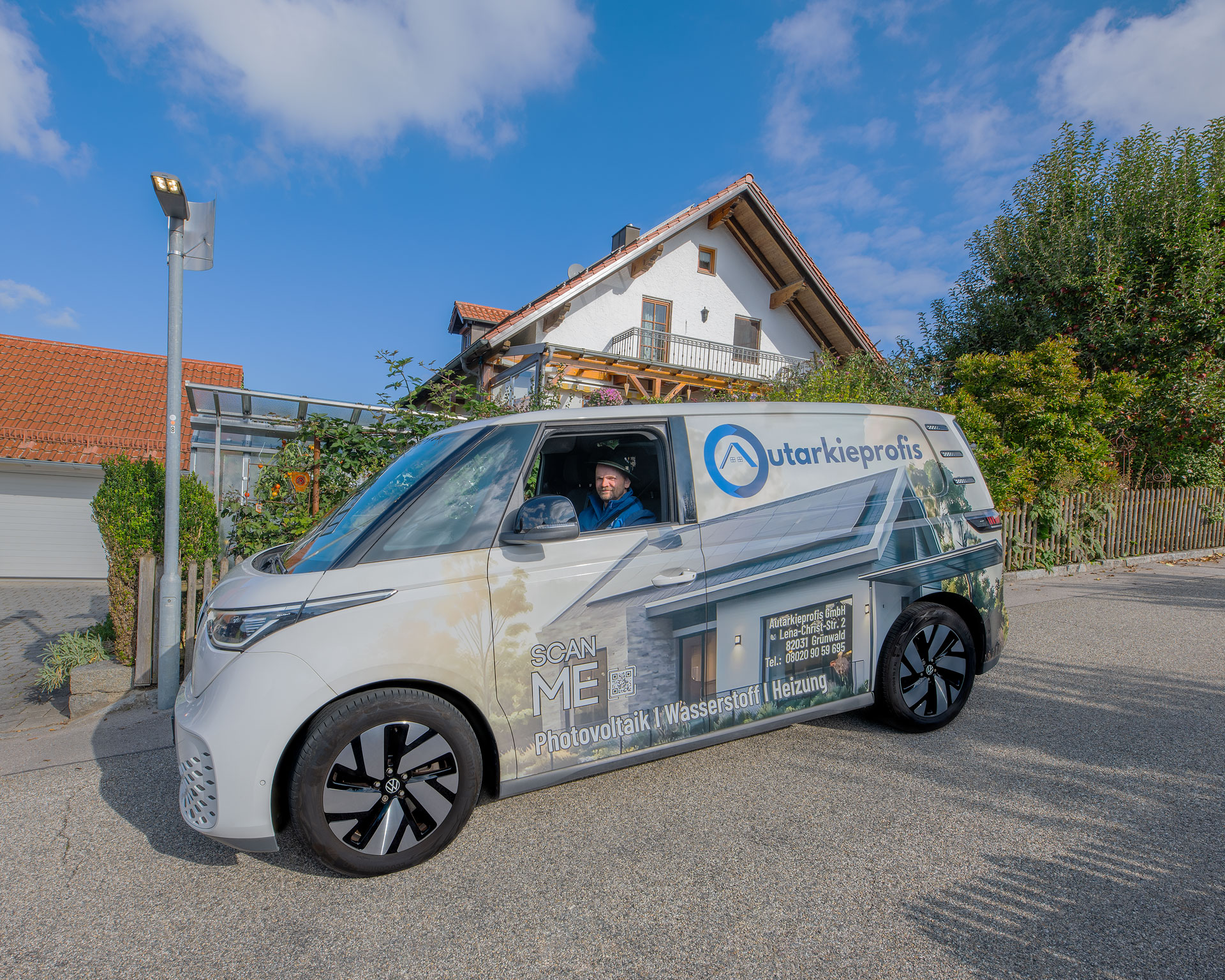 Gebrandeter E-Van der Autarkieprofis vor Wohnhaus – Vor-Ort-Service fuer PV-Anlage und Heiztechnik
